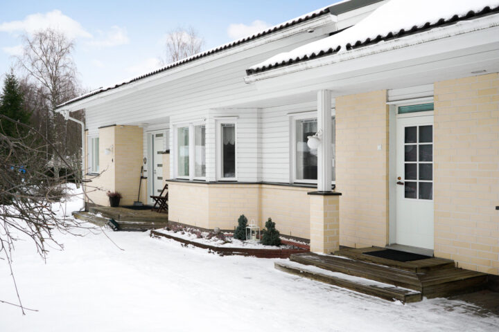 Omakotitalon julkisivu ikkunaremontin jälkeen. Valkoiset ikkunat sopivat raikkaaseen tiilitalon ilmeeseen.